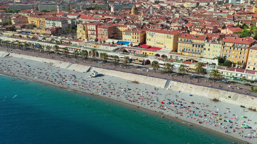 Aerial drone view of Nice Old Town with colorful buildings, terracotta rooftops, and busy beachfront