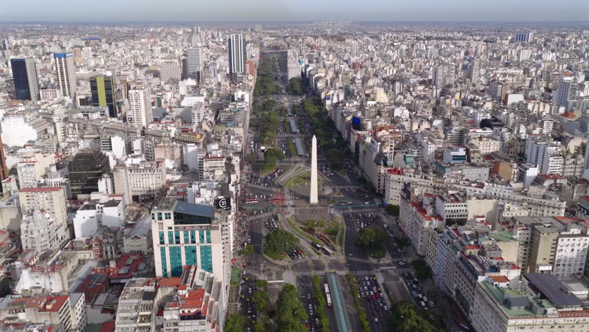 Aerial drone view of Buenos Aires cityscape showing Avenida 9 de Julio and Obelisk, dense buildings, and urban traffic in Argentina.