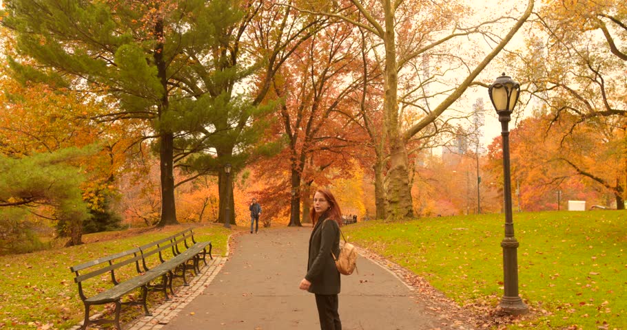 Young Woman Strolling In Central Park With Vibrant Fall Colors Nature In New York City, United States. Static Shot