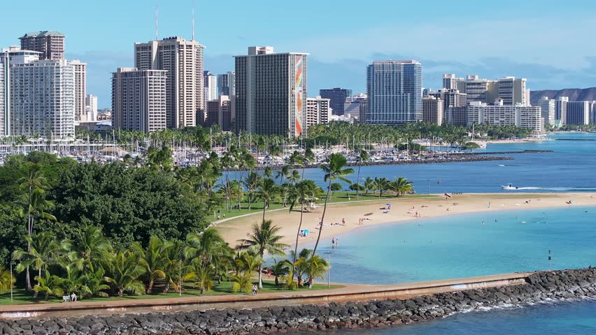 Beautiful aerial view of the Honolulu beach city in Hawaii. Magical holiday paradise summer vibes. Best tourist destination. Beautiful Hawaii with golden beaches, Pacific ocean waves and palm trees. 