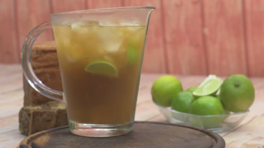 Pouring Venezuelan limeade into a mason jar, refreshing drink outdoors