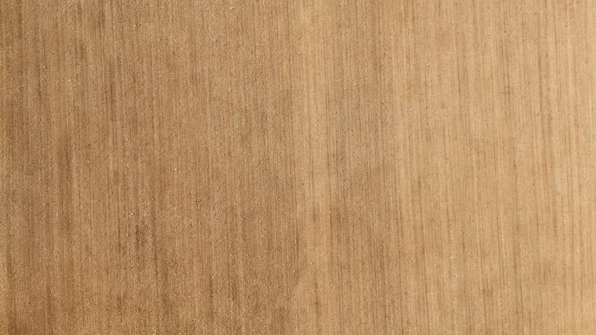 High aerial top‑down view of a lone vintage crawler tractor crossing a harvested field in the Tuscan countryside, Italy, creating subtle lines and textures in the dry soil.