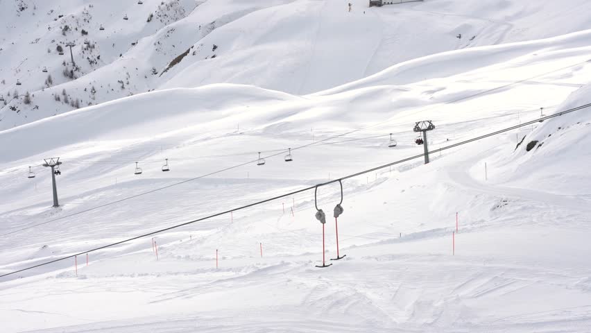 Deserted ski resort with a running t bar lift on a sunny day in the mountains