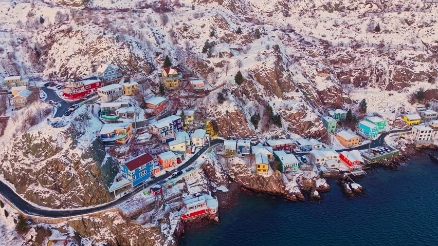 Vibrant houses line a snowy cliffside road in the Battery, St. John