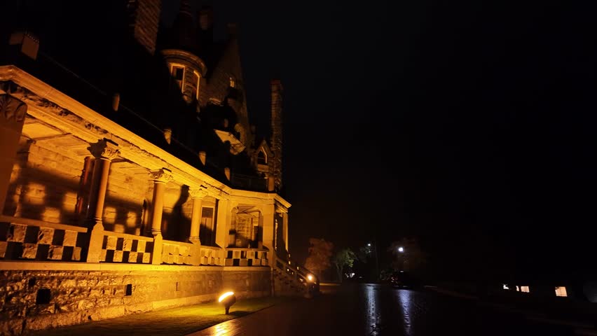 Gimbal close-up panning shot of the historic Craigdarroch Castle on a rainy evening in Victoria, British Columbia, Canada. 4K