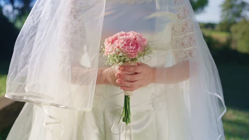 Bride holding bouquet of roses during wedding