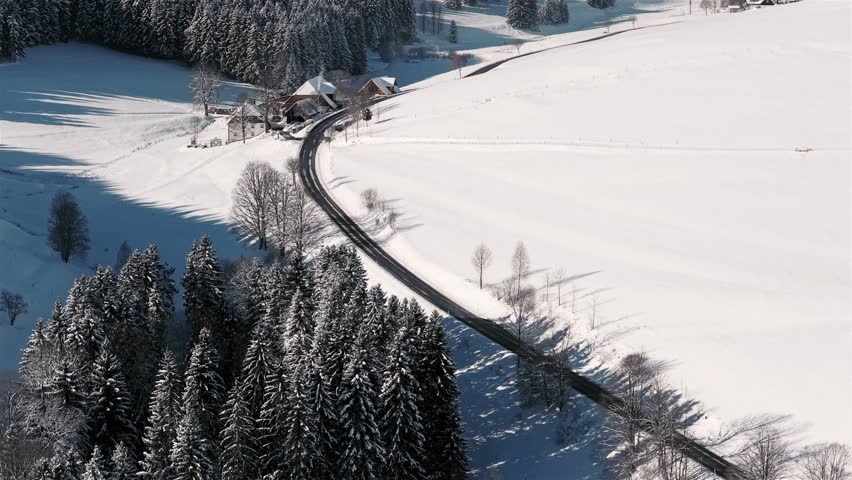 Truck driving in winter through snow covered nature in the Black Forest
