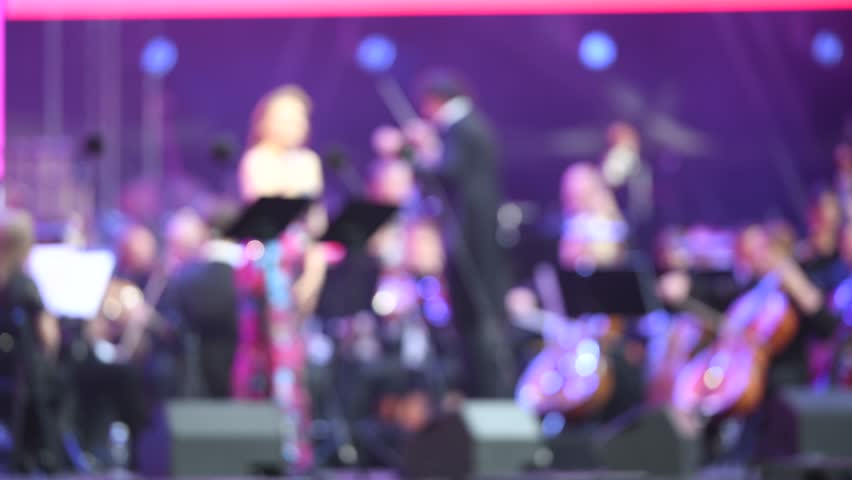 Abstract View of Orchestra Performance with Artistic Lighting Effects. Singer on the Stage