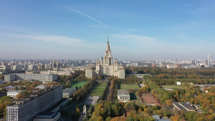 Drone lowering above autumn park and city