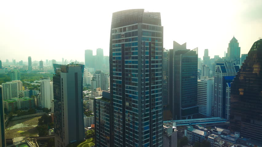Aerial drone view of modern high-rise buildings and dense urban skyline in Bangkok, Thailand. Contemporary skyscrapers, business district architecture, and expansive cityscape
