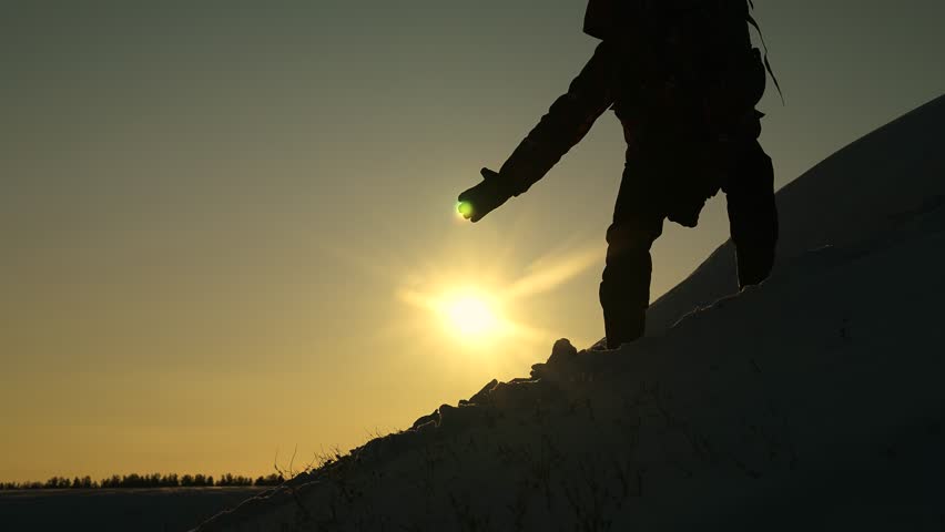Travelers reach out to each other, climbing to top of hill. Teamwork of business people. Reach your goal. Travelers climb peak of success, silhouette rock climbers. Victory of business team. Suns snow
