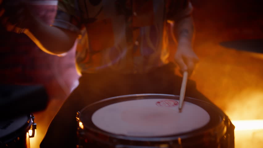 Talented guy playing drum making beat at rock concert in modern night bar closeup. Enthusiastic man musician performing bass rhythm at nightclub. Professional drummer enjoy percussion instrument sound