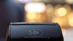 Customer making a quick and secure payment using a smartphone with nfc technology on a pos terminal, representing a modern cashless transaction method with a beautiful bokeh  - Powered by Shutterstock - Get 15% off with code: PIKWIZARD15