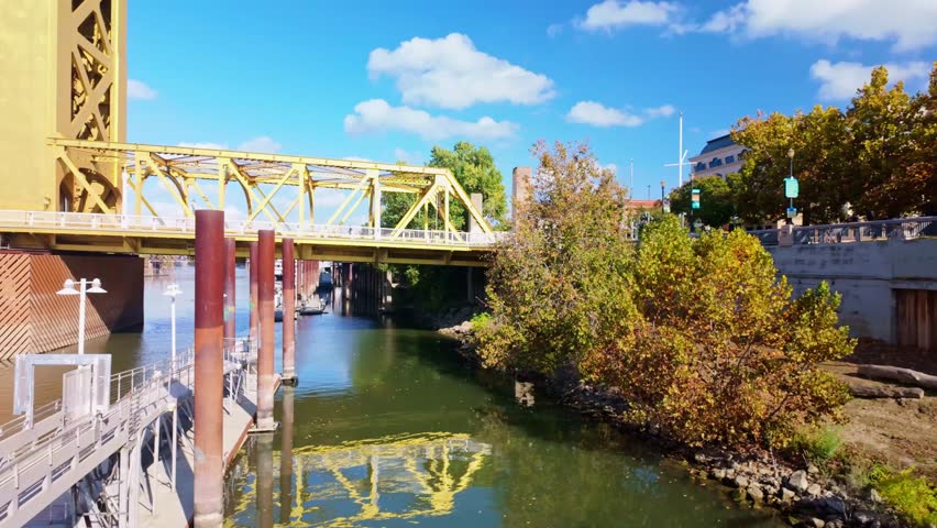 Golden Tower Bridge spanning the Sacramento River under a bright blue sky on a clear sunny day