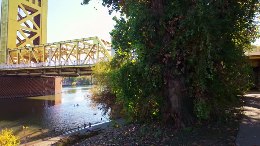 Golden Tower Bridge spanning the Sacramento River under a bright blue sky on a clear sunny day