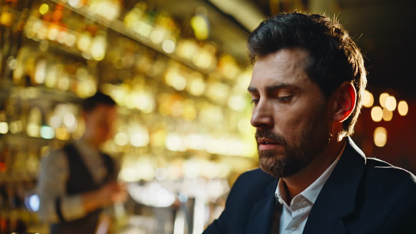 Bar client lighting cigarette sitting at night pub counter portrait. Weary man holding matches feeling depressed closeup. Exhausted businessman smoking alone thinking life problems at evening lounge
