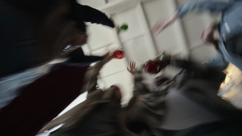 Low angle blurred motion shot of wild party in abandoned house with unrecognizable young people dancing and drinking alcohol