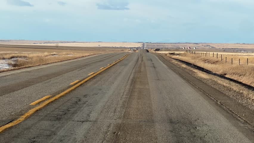 Driving along a rural Alberta highway on a sunny winter day