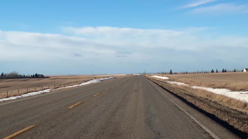 Driving along a rural Alberta highway on a sunny winter day