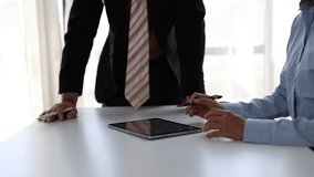 Two business professionals analyzing financial data and charts on a digital tablet screen during a meeting, gesturing and discussing a new project strategy in their corporate workplace - Powered by Shutterstock - Get 15% off with code: PIKWIZARD15