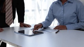Two anonymous business partners analyzing financial data and charts on paper and a tablet before successfully concluding a deal with a firm handshake in a modern, bright office environment - Powered by Shutterstock - Get 15% off with code: PIKWIZARD15