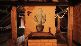 Cactus mural painted on rustic chimney in attic with glowing lights and hammock - Powered by Shutterstock - Get 15% off with code: PIKWIZARD15