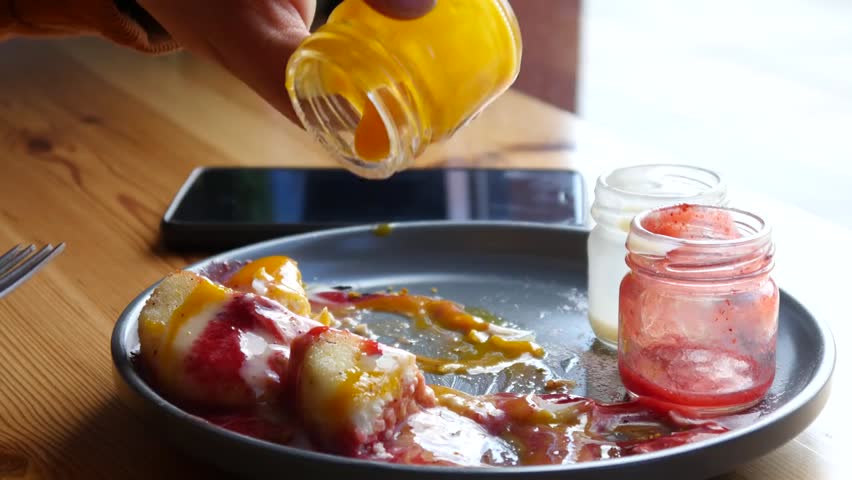 Close-up of a breakfast plate with pancakes and jam, a delicious morning meal in a cozy setting.
