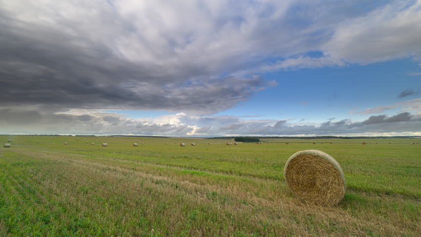 An Expansive and Beautiful Landscape Featuring Hay Bales Under Dramatic Skies that Inspire