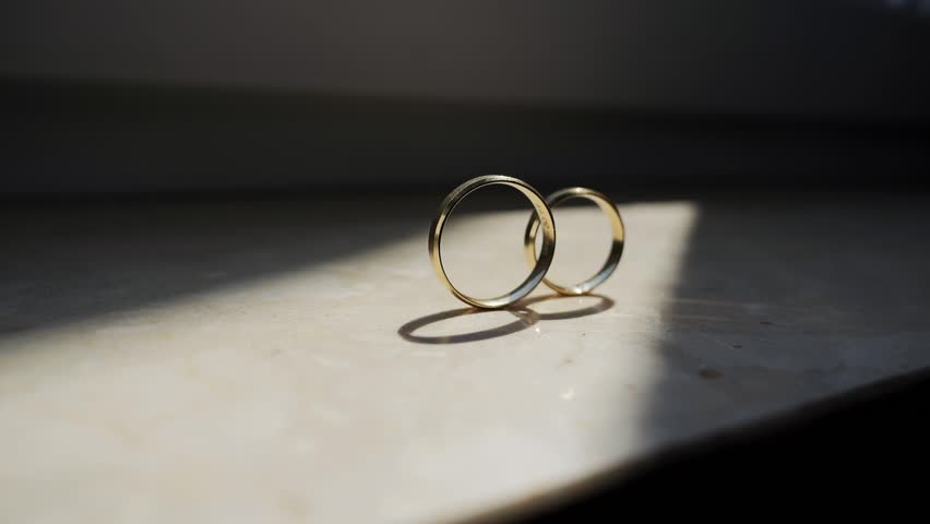 Wedding Rings on Window Sill Bathed in Sunlight