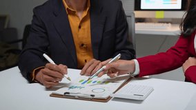 Two business colleagues analyzing and discussing financial charts and graphs during a meeting - Powered by Shutterstock - Get 15% off with code: PIKWIZARD15