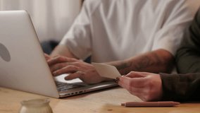 Close up of a man entering payment information on a laptop while a woman holds the credit card - Powered by Shutterstock - Get 15% off with code: PIKWIZARD15