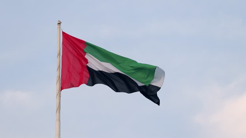 UAE flag waving in the blue sky, national symbol of UAE. High quality 4k footage.