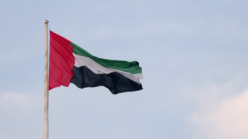 UAE flag waving in the blue sky, national symbol of UAE. High quality 4k footage.