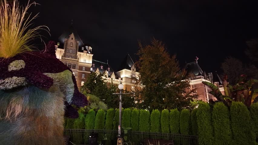 Gimbal close-up panning shot of the Surfacing Orcas garden sculpture during a rainy night in downtown Victoria, British Columbia, Canada. 4K