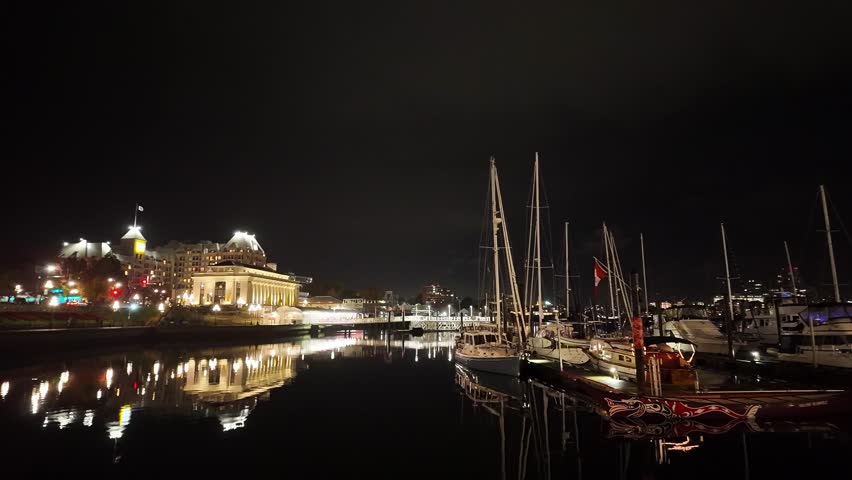 Gimbal wide panning shot of the causeway surrounding the Inner Harbour during a rainy night in Victoria, British Columbia, Canada. 4K