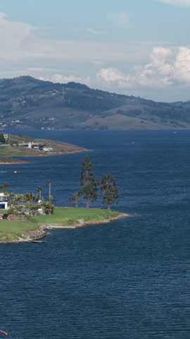 Breathtaking aerial footage of Lago Calima in Valle del Cauca, featuring lush landscapes and deep blue waters. Ideal vertical video for social media, capturing vibrant Colombian scenery.