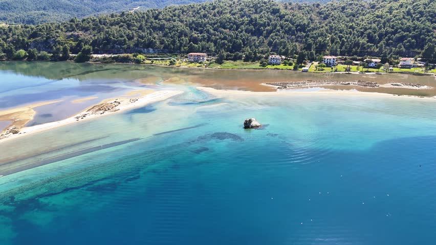 Aerial drone view of Fteroti Beach with sandbanks, shallow lagoon and turquoise water in Sithonia, Chalkidiki, Greece. Coastal Mediterranean landscape.