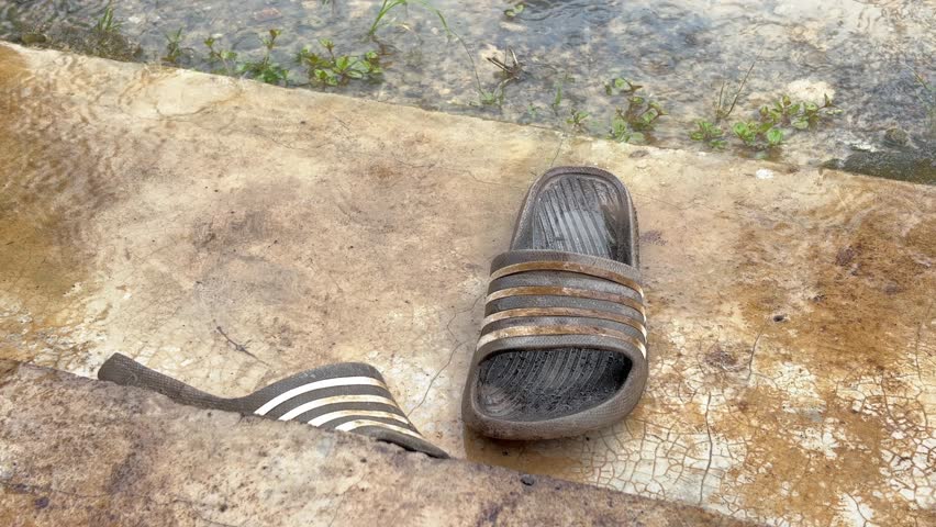 Worn Flip Flops Soaked by Rain on House Terrace
