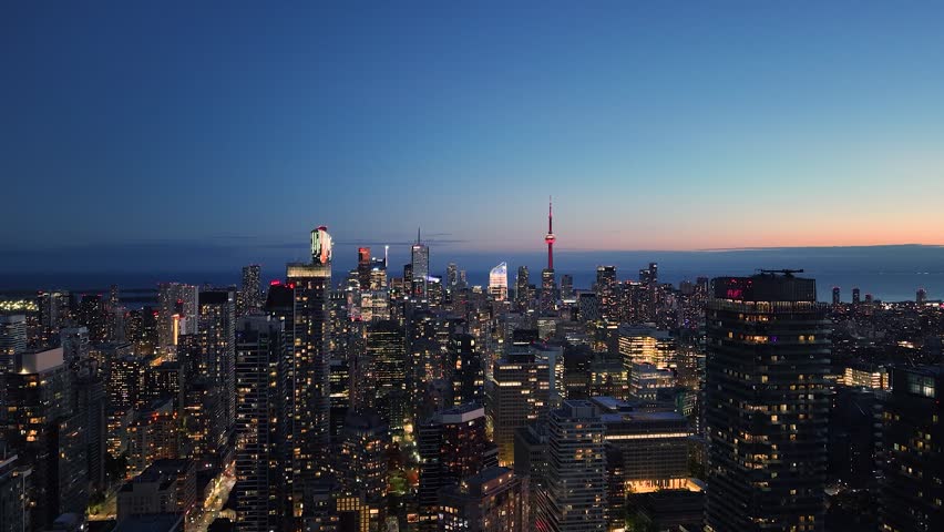 Drone view of the evening Toronto skyline. City lights. Downtown skyscrapers viewed from above. Toronto, Ontario, Canada.