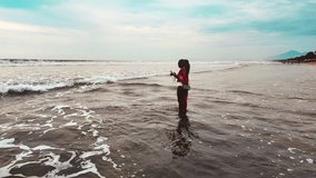 Woman in red enjoys Kuta Beach with waves in slow motion - Powered by Shutterstock - Get 15% off with code: PIKWIZARD15