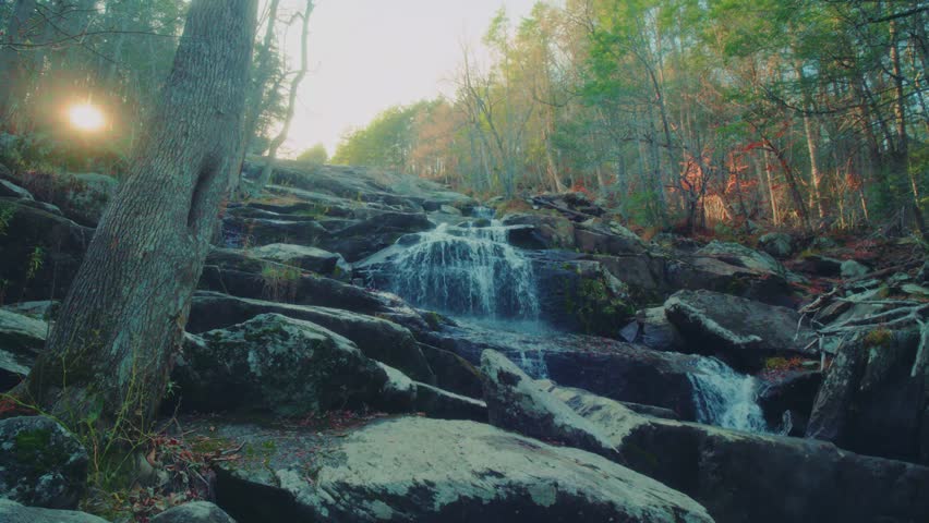A beautiful, long waterfall run known as Glendale Falls cascades over natural rock ledges amidst an autumn forest in Middlefield, Massachusetts. Fed by Glendale Brook, these powerful falls are a hidde
