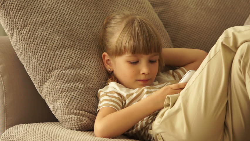 Little girl resting on the couch and dials the number
