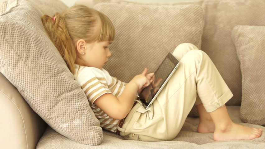 Little girl plays a game on the tablet and nervous
