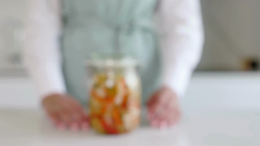 Person opening a jar of kimchi in 4K, showing hands-on preparation, authentic Korean fermented vegetables, fresh ingredients, and traditional culinary process for appetizing food visuals.