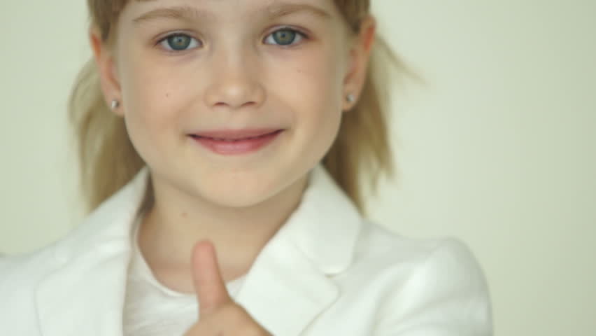 Young businesswoman standing and shows thumb up
