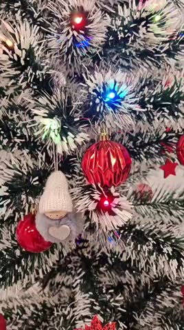 Close-Up of Decorated Christmas Tree with Red Ornaments and Colorful Lights