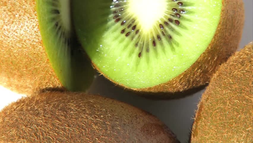 Close-up macro footage of fresh kiwi fruit sliced open to show bright green flesh and black seeds. The juicy texture and natural freshness make this video ideal for health food, vitamin C, organic produce, vegan and vegetarian diet, smoothie ingredients, nutrition, and clean eating concepts. Perfect for food advertising, wellness content, social media videos, cooking projects, and colorful fruit background use.