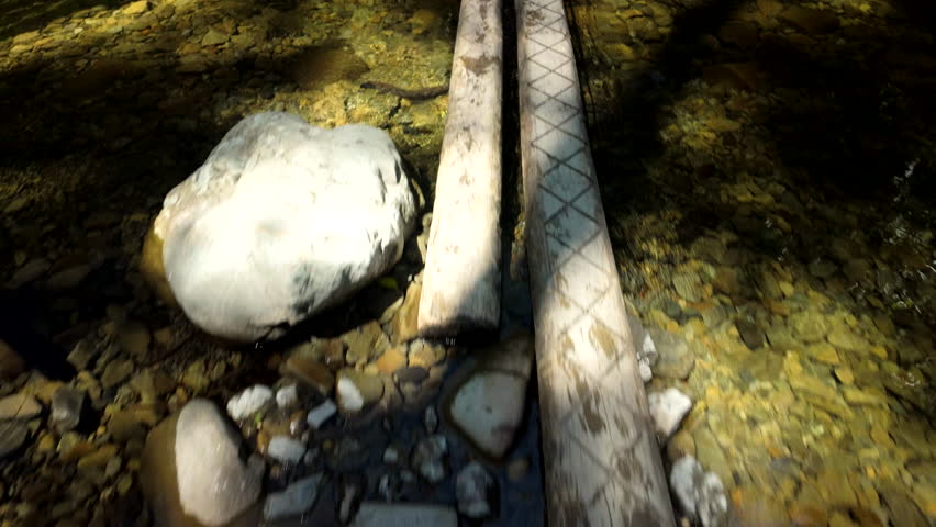 Narrow Wooden Plank Bridge Over Clear River