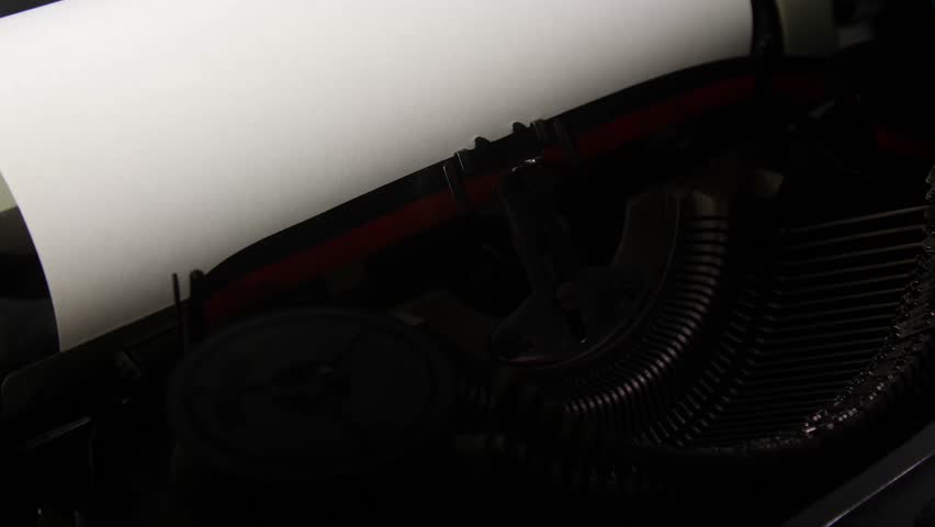 Vintage typewriter device printing the word typewriter on a piece of white paper, representing communication, retro technology, and the act of writing