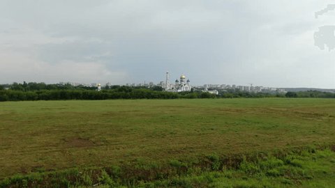 Gentle Drone Ascent above Fields toward Monastery